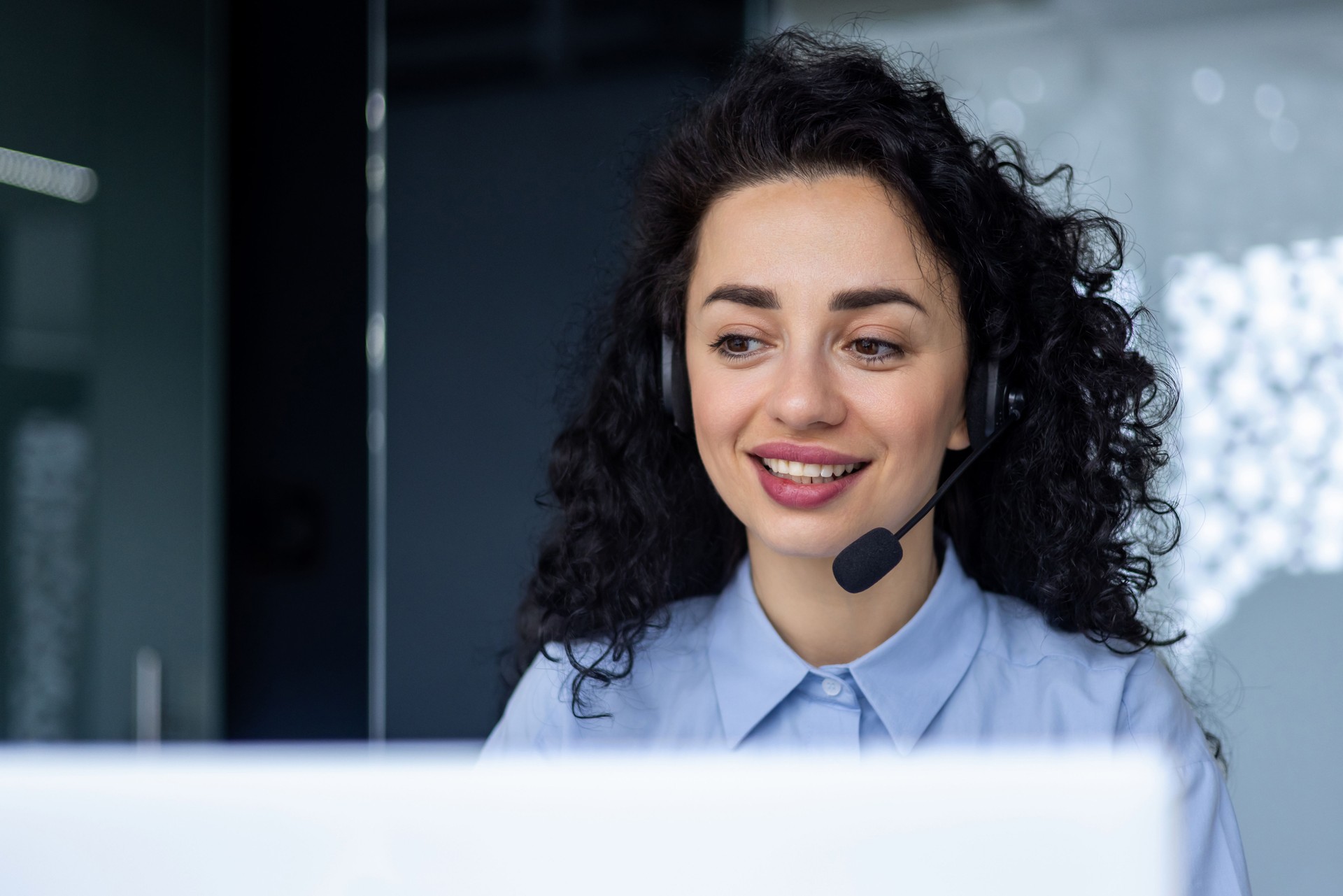 Exitosa mujer hispana con teléfono con auriculares para videollamada trabajando con una computadora portátil mientras está sentada en el lugar de trabajo, departamento técnico de soporte de servicio al cliente en línea, empresaria sonriente y feliz co